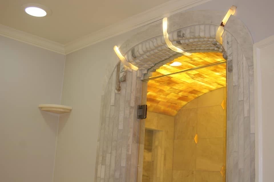 Detail of award-winning masterbath wall showing onyx niche with backlit stone and natural veining